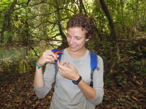 Courtney holding a kingfisher in the woods