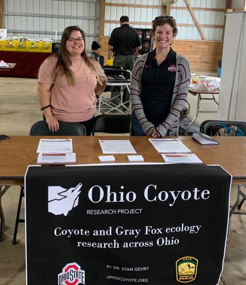 Courtney and Abby stand at their information table at the OSTA convention.